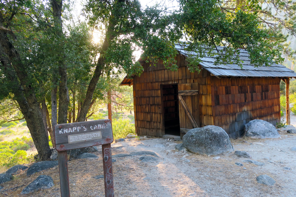 old cabin with no door with a tree and a sign that says knapp's cabin