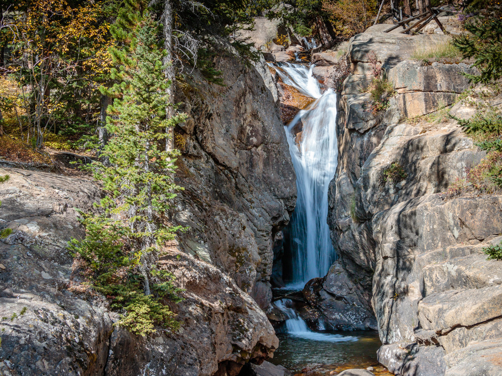 waterfall and trees in rocky landscape